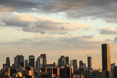 View of cityscape against cloudy sky