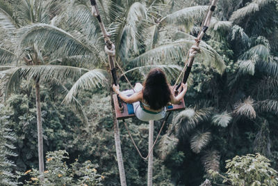 Young pretty asian woman is swinging on the cliff of the jungle in ubud, bali.