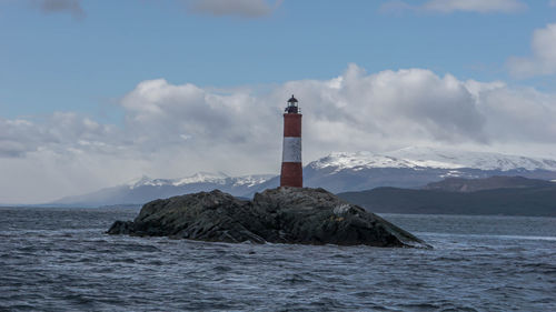 Lighthouse by sea against sky