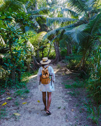 Rear view of woman walking on field