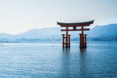 Itsukushima temple in bay against sky