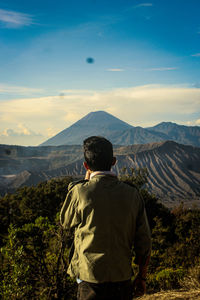 Rear view of man looking at volcano