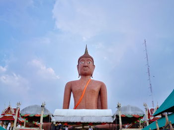 Low angle view of statue against building against sky