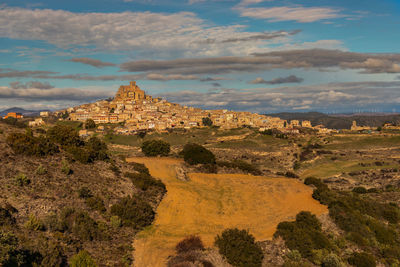 View of castle on landscape against cloudy sky