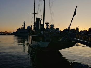 Sailboats in sea at sunset