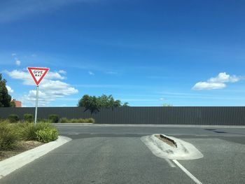 Road sign against sky