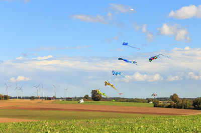 Giant kites in the air with windturbines in the background