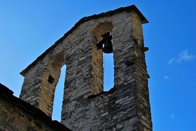 Low angle view of bell tower against blue sky