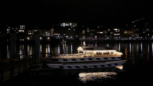 Boats moored in city at night