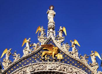 Statues and carvings on saint mark basilica against clear blue sky