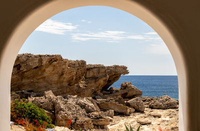 View out of an archway at the rocky coastline at kallithea therms, kallithea spring on rhodes island