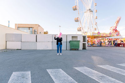 Rear view of woman standing in amusement park