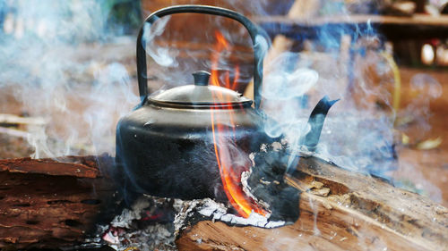 Close-up of burning candles on wooden log