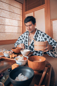 Young man preparing food at home in japan