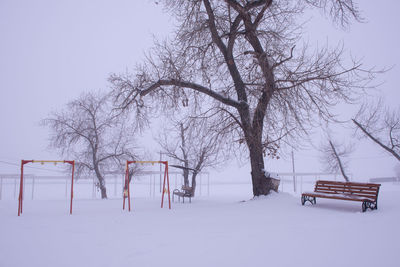 Snow covered field against clear sky