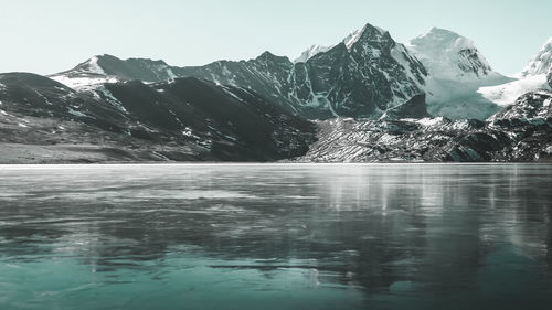 Scenic view of lake by mountain against sky