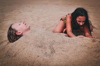 High angle view of girl lying on sand at beach