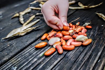 Close-up of hand holding vegetables on table