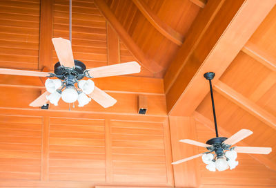 Low angle view of electric lamp hanging at home