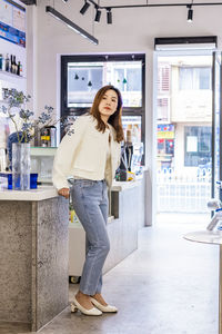 Portrait of smiling young woman standing in store