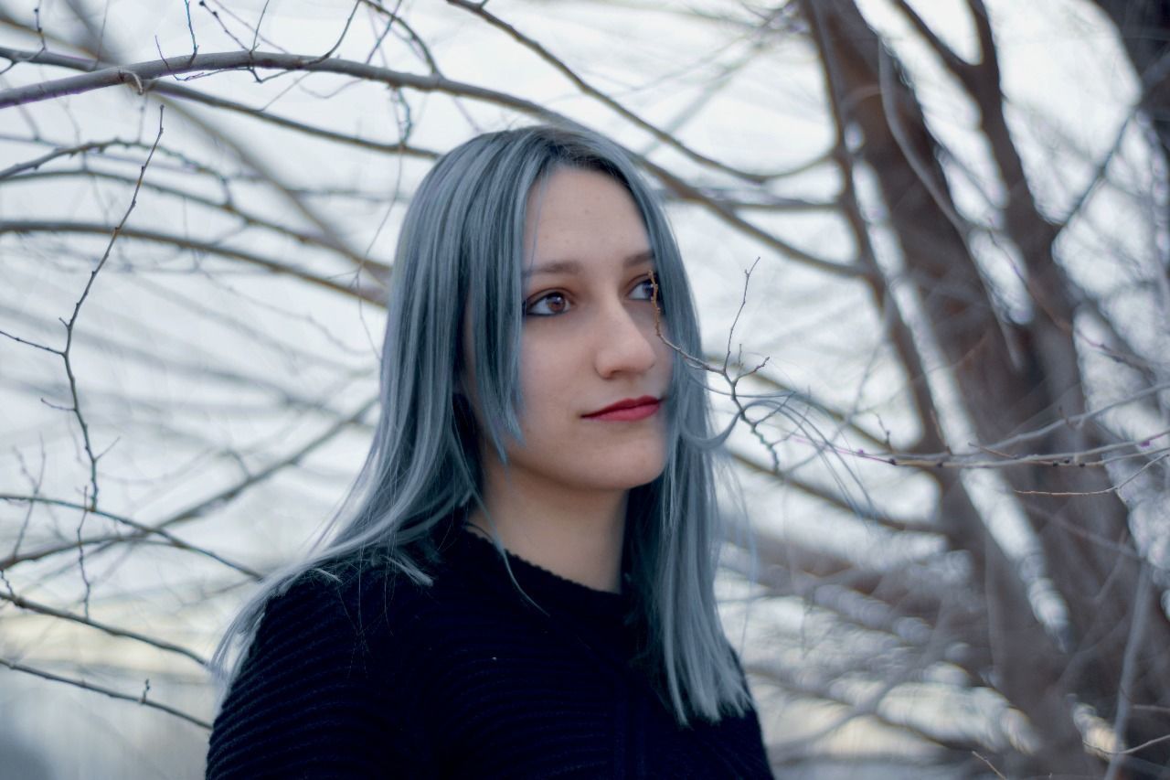 young adult, young women, serious, one person, looking at camera, front view, real people, beautiful woman, portrait, tree, lifestyles, headshot, focus on foreground, bare tree, close-up, outdoors, standing, day, branch