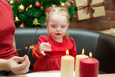 A small child celebrates christmas for the first time. 