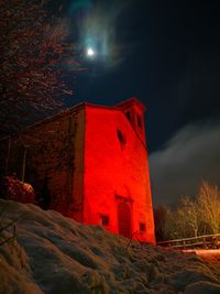 Low angle view of illuminated building against sky at night