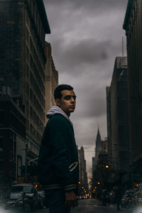 Man standing on city street at dusk