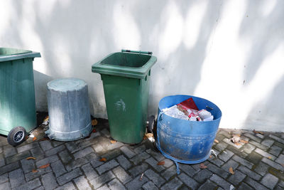 High angle view of garbage can on street against wall