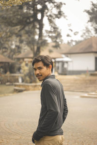 Portrait of young man standing on land