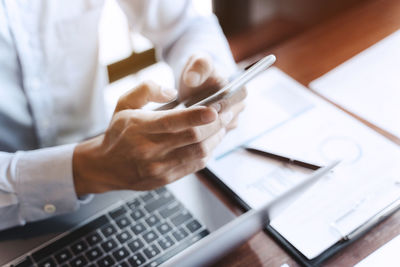 Midsection of man using laptop on table