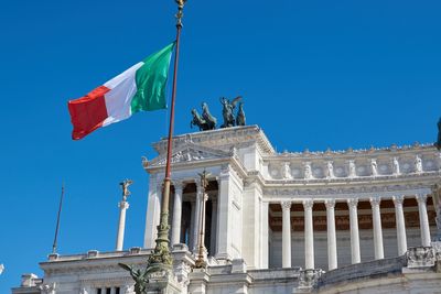 Low angle view of italian flag against altare della patria