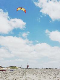 Low angle view of person paragliding against sky