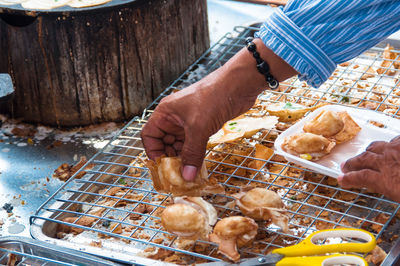 Midsection of person eating food on table