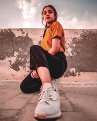 Portrait of boy sitting on land against sky