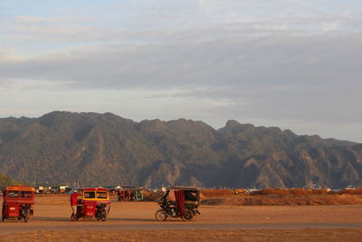 Bicycles on road by mountains against sky