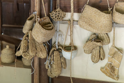 Close-up of straw shoes and bags hanging on rope at a rural house