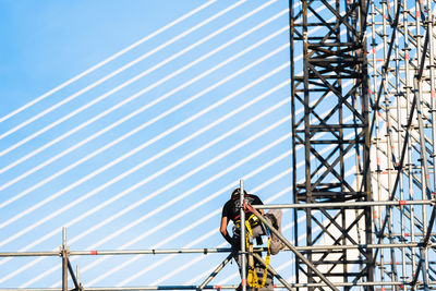 Low angle view of construction crane against blue sky