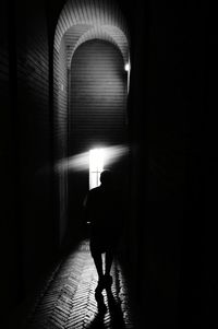 Rear view of man in illuminated corridor