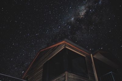 Low angle view of house against star field