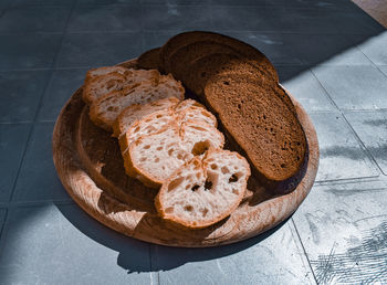 Sunlit bread slices on wooden cutting board