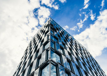 Low angle view of modern building against cloudy sky