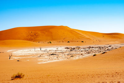 Scenic view of desert against clear blue sky