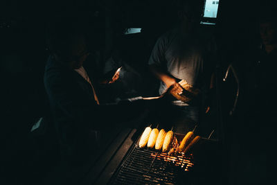 Midsection of man preparing food in dark