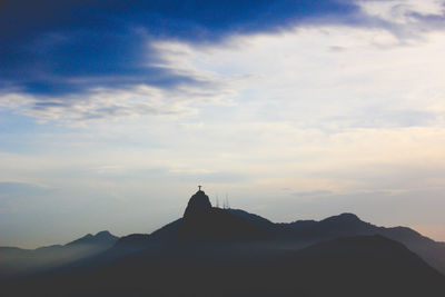 Scenic view of mountains against cloudy sky