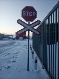 Information sign on snow covered road against sky