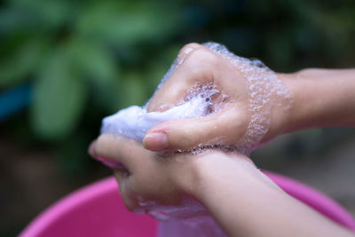 Cropped hands of woman washing cloth