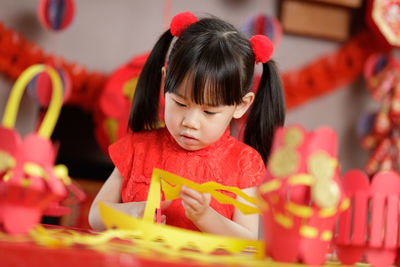 Young chinese girl making traditional chinese fu means lucky lantern for celerating chinese new year
