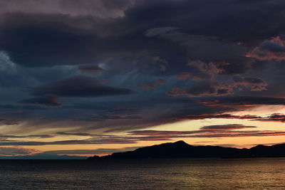 Scenic view of sea against dramatic sky during sunset