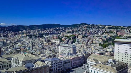 High angle view of city against blue sky